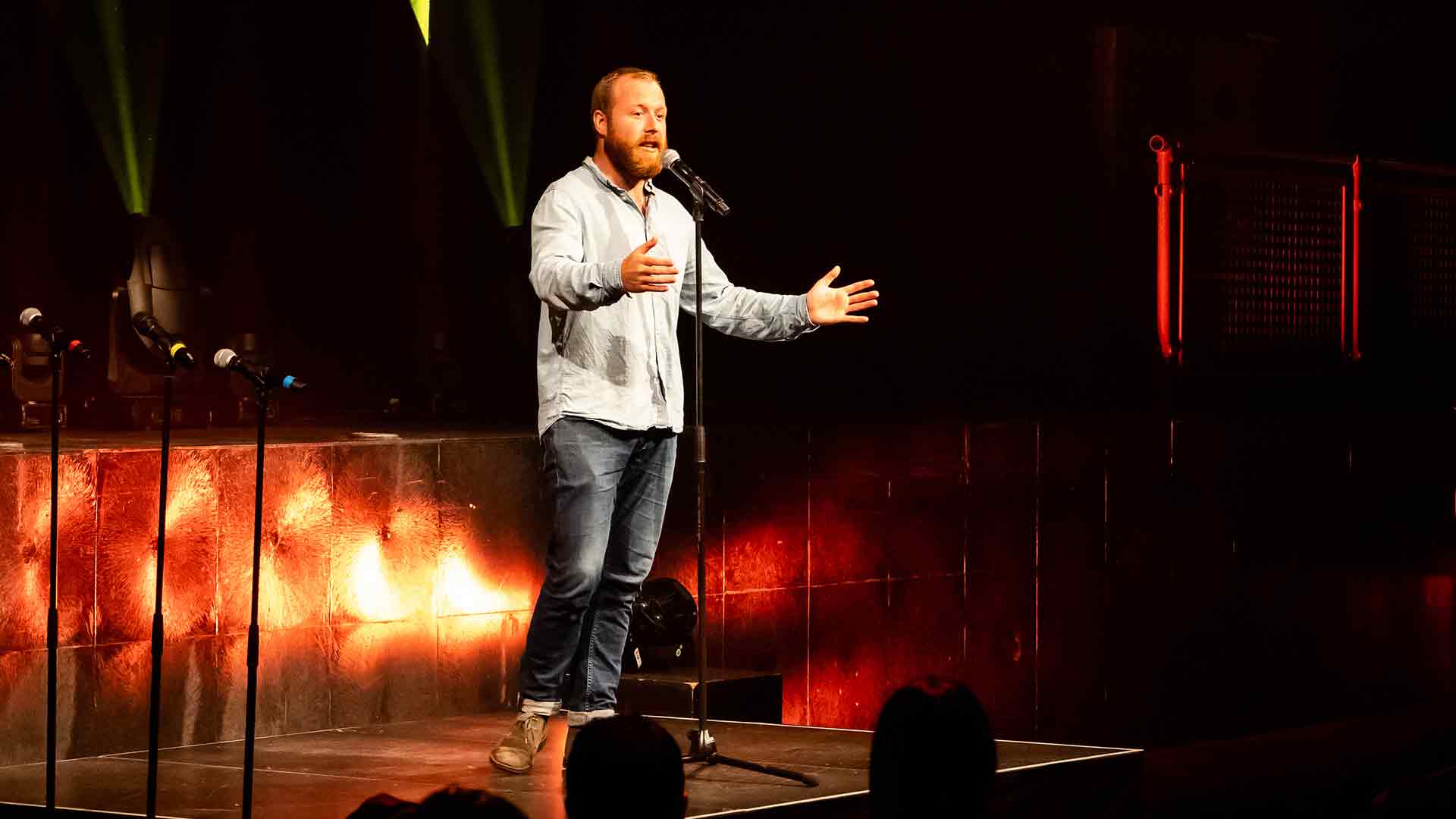Image of Stephen Bell on stage performing comedy.